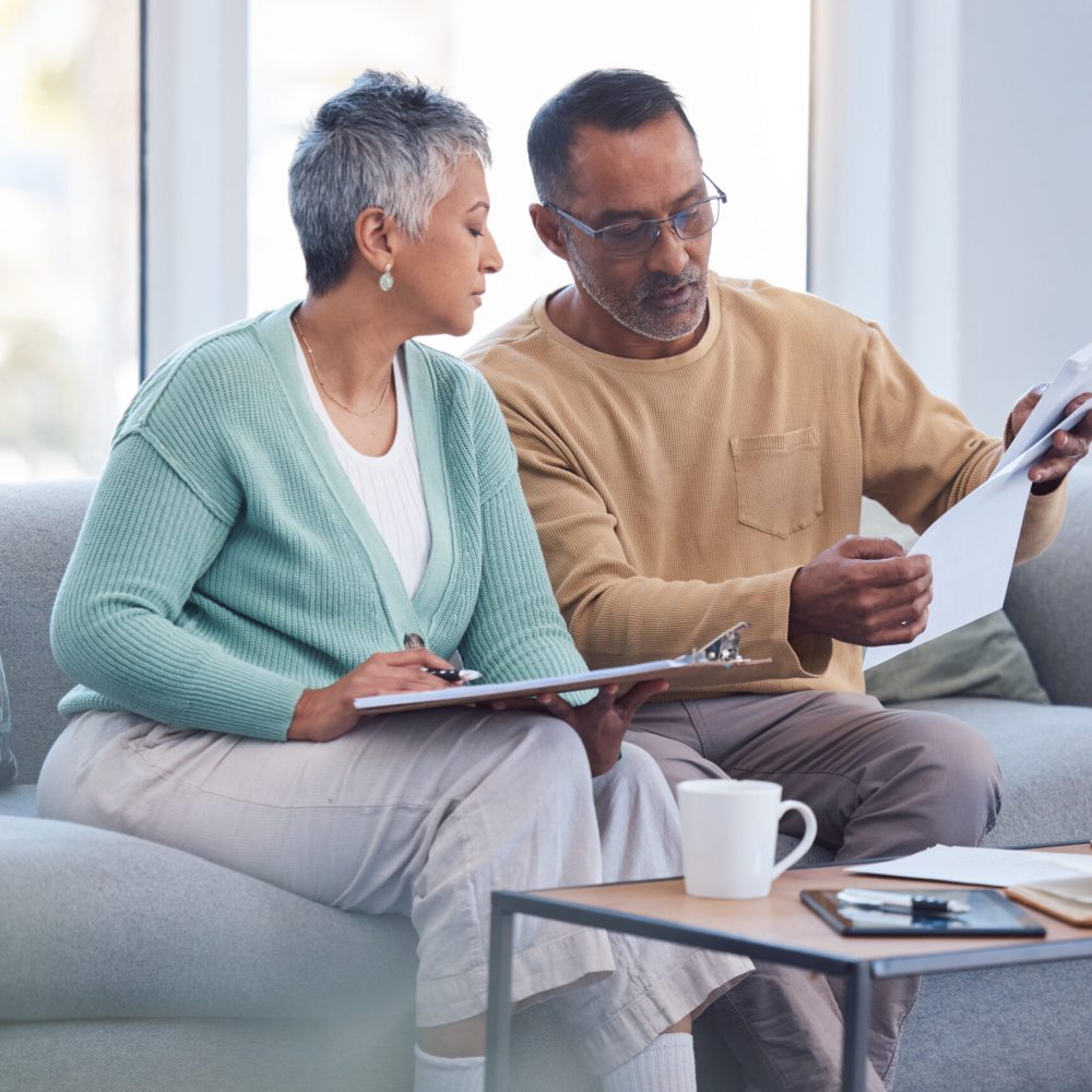 Finance, documents and senior couple on sofa with bills, paperwork and insurance checklist in home, life or asset management, Elderly black people on couch with financial, retirement or mortgage debt.